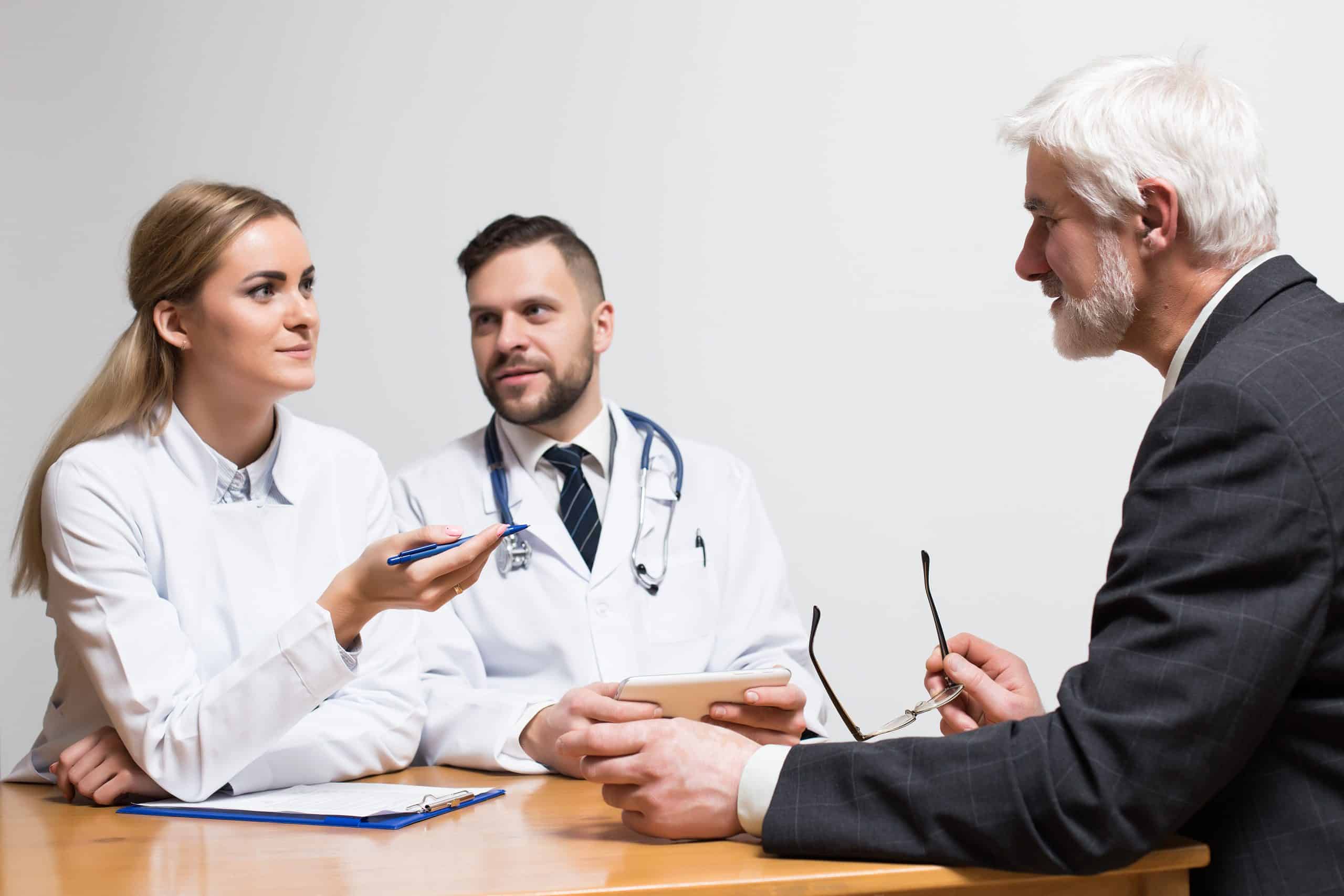 Doctors reviewing a HIPAA business associate agreement (BAA) with a lawyer to ensure the contract's compliance and accuracy.